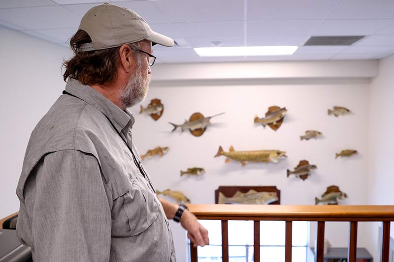 Matthews stands at a balcony at the Norris fish lab. The species on display are native to the Valley region